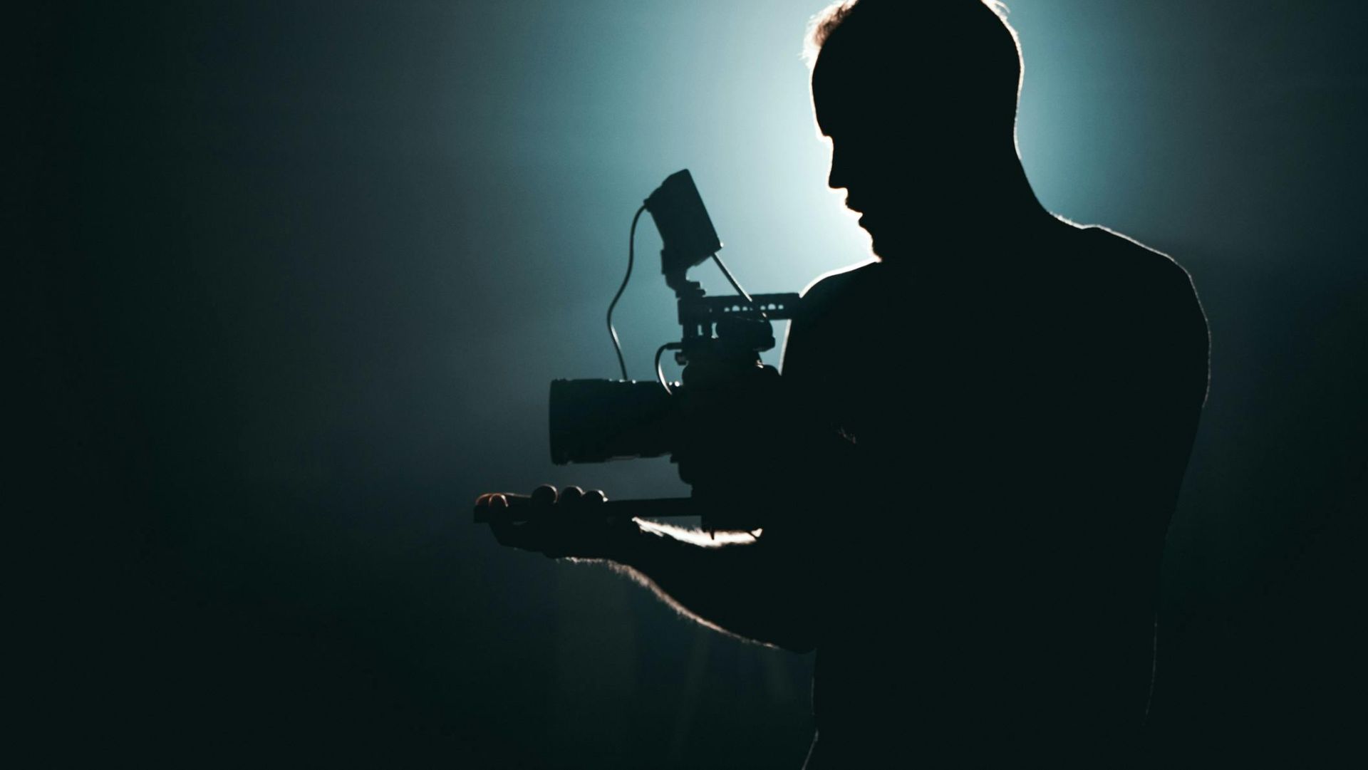 Silhouette of Man Standing in Front of Microphone